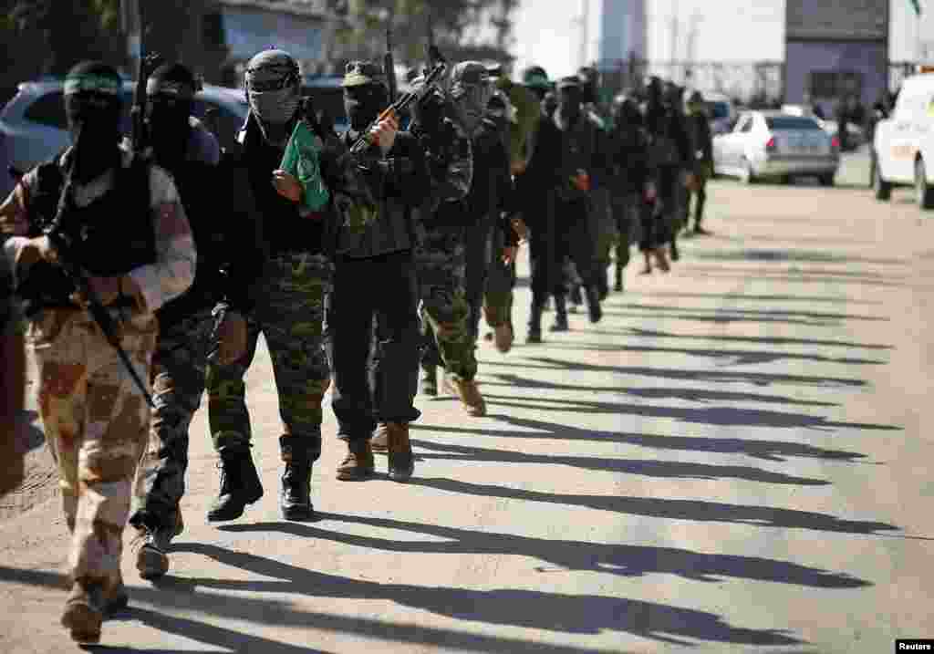 Palestinian members of the al-Qassam brigades, the armed wing of the Hamas movement, patrol a street as they await the arrival of Hamas chief Khaled Meshaal in Rafah in the southern Gaza Strip, December 7, 2012. 
