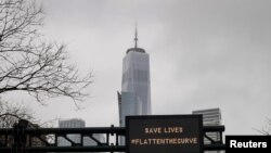 One World Trade is seen behind a sign that flashes an emergency alert, as the coronavirus disease (COVID-19) outbreak continues in New York City, New York.