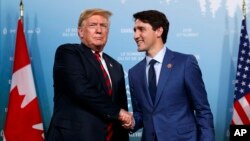 FILE - President Donald Trump meets with Canadian Prime Minister Justin Trudeau during the G-7 summit, June 8, 2018, in Charlevoix, Canada.