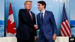 FILE - President Donald Trump, left, meets with Canadian Prime Minister Justin Trudeau during the G-7 summit, June 8, 2018, in Charlevoix, Canada.