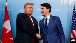 FILE - President Donald Trump meets with Canadian Prime Minister Justin Trudeau during the G-7 summit, June 8, 2018, in Charlevoix, Canada.