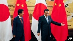 Japanese Prime Minister Shinzo Abe, left, and Chinese Premier Li Keqiang prepare to leave after attending a signing ceremony at the Great Hall of the People in Beijing, Oct. 26, 2018.