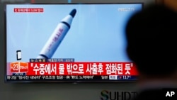 Putnik na železničkoj stasnici u Seulu posmatra izveštaj na televiziji o balističkoj probi Severne Koreje