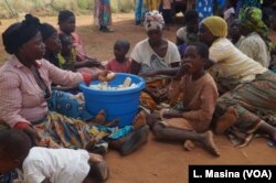 Struggling with food shortages in camps, floods victims prepare maize - the only item they were able to secure by working at nearby farms.