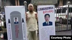 Nhà hoạt động nhân quyền Wu Gan bên 2 tấm biển bêu xấu người đứng đầu tòa thượng thẩm Jiangxi. Ông Wu bị kết án 8 năm tù giam với cáo buộc "lật đổ chính quyền."