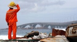 FILE - A construction worker looks on as the China-funded Sinamale bridge is seen in Male, Maldives, Sept. 18, 2018.