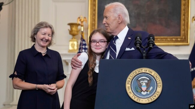 El presidente Joe Biden abraza a Miriam Butorin, hija pequeña de la periodista liberada Alsu Kumarsheva , mientras Elizabeth Whelan, (izq), observa después de pronunciar un discurso sobre un intercambio de prisioneros con Rusia, en la Casa Blanca, el 1 de agosto de 2024.