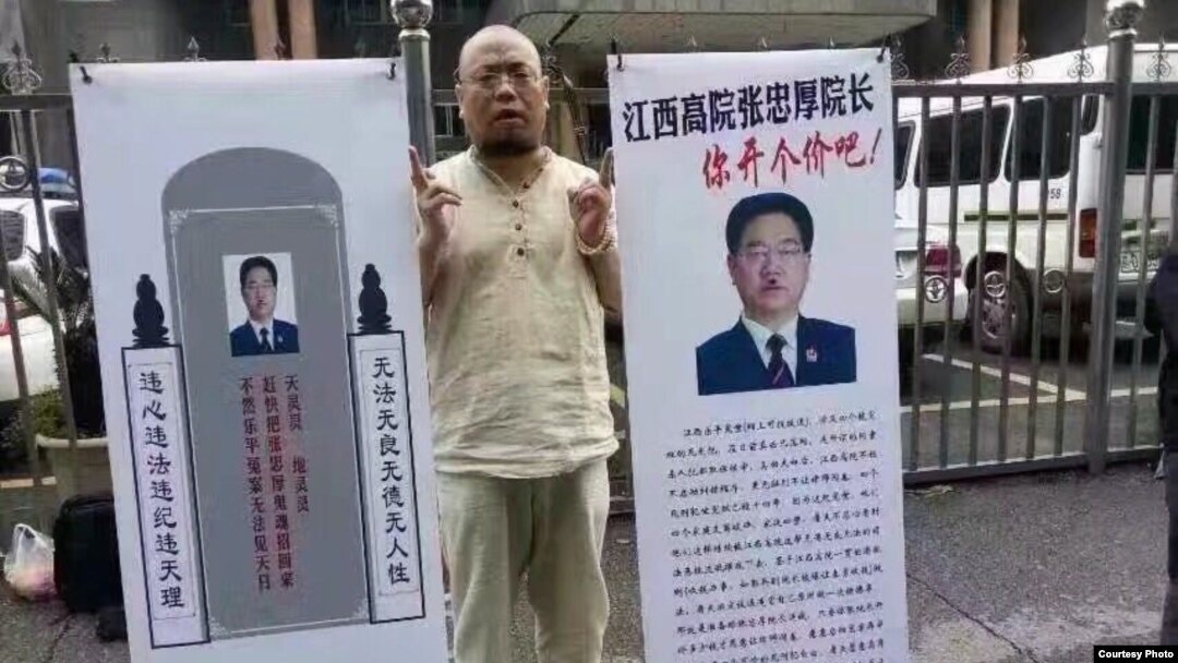 Aktivis HAM Wu Gan membawa poster yang memperolok-olok Kepala Pengadilan Jiangxi, China (foto: dok). 