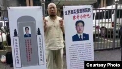 Aktivis HAM Wu Gan membawa poster yang memperolok-olok Kepala Pengadilan Jiangxi, China (foto: dok). 