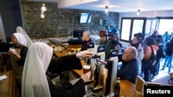 Las monjas de la orden Hermanas Peregrinas de la Eucaristia sirven bebidas en el bar Amaren Etxea (Casa de la Madre), en el Santuario de Estibaliz en Villafranca de Estibaliz, norte de España, el 24 de marzo de 2024. 