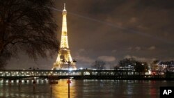 FILE - A flooded street lamp and signboards are pictured next to the river Seine in Parison the river Seine in Paris, Jan. 27, 2018. 