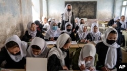 FILE - Afghan school girls attend their classroom on the first day of the new school year, in Kabul, March 25, 2023. Girls are not allowed to study beyond sixth grade.