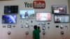 FILE - A man looks at a device a the YouTube booth at Google I/O 2013 in San Francisco.