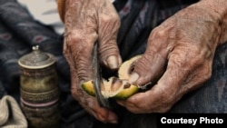 FILE - A 90-year-old Thai woman uses a pair of traditional metal cutters to slice open an areca nut that she will then chew mixed with betel leaf and lime paste to form a mild stimulant. (Photo taken by Matthew Richards/Thailand/VOA reader)