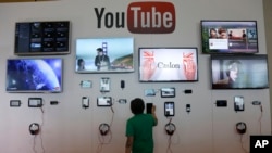 FILE - A man looks at a device a the YouTube booth at Google I/O 2013 in San Francisco.