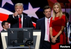 FILE - Republican presidential nominee Donald Trump gives a thumbs up as his campaign manager Paul Manafort, center, and daughter Ivanka look on during Trump's walk through at the Republican National Convention in Cleveland, July 21, 2016.