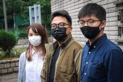 FILE - Agnes Chow, left, Ivan Lam, center, and Joshua Wong are seen outside West Kowloon Court, Hong Kong, Nov. 23, 2020. All were sentenced to jail Dec. 2, 2020. (Tommy Walker/VOA)