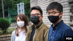 Agnes Chow, left, Ivan Lam, center, and Joshua Wong are seen outside West Kowloon Court, Hong Kong, Nov. 23, 2020. All were sentenced to jail Dec. 2, 2020. (Tommy Walker/VOA)