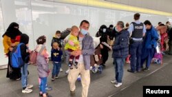 FILE - A group of Afghan support staff arrive with their families at Frankfurt airport, Germany, Nov. 2, 2021.