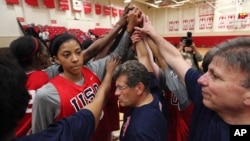 Head coach Geno Auriemma, center, joins Candace Parker, left, and the rest of the US women's basketball Olympic team in a huddle as they complete practice Friday, May 11, 2012, in Seattle.