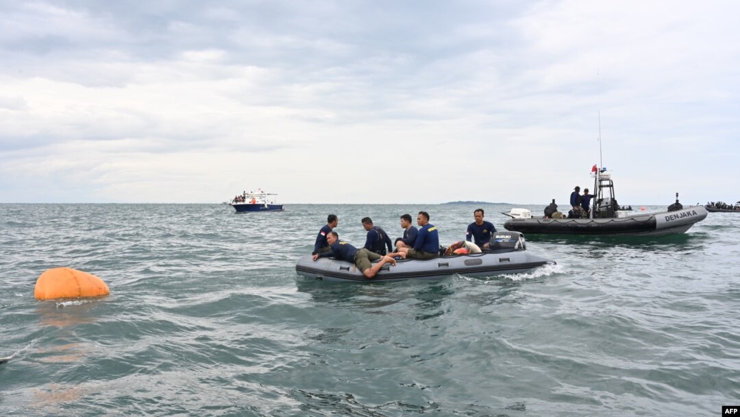 Penyelam Angkatan Laut menggunakan perangkat pelampung untuk mengambil puing-puing pesawat penumpang Boeing 737-500 Sriwijaya Air di dekat Pulau Lancang pada 10 Januari 2021. (Foto: AFP)
