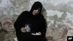 Palestinian Nadia Abu Nada holds a picture of her son Ihab Abu Nada, who set himself on fire because he could not find a job, in Gaza City, September 3, 2012. 