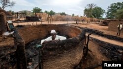 ARCHIVES - Un homme à l'intérieur d'une maison incendiée lors d'affrontements entre nomades et résidents dans le village de Deleij, situé dans la localité de Wadi Salih, au Darfour central, au Soudan, le 11 juin 2019.