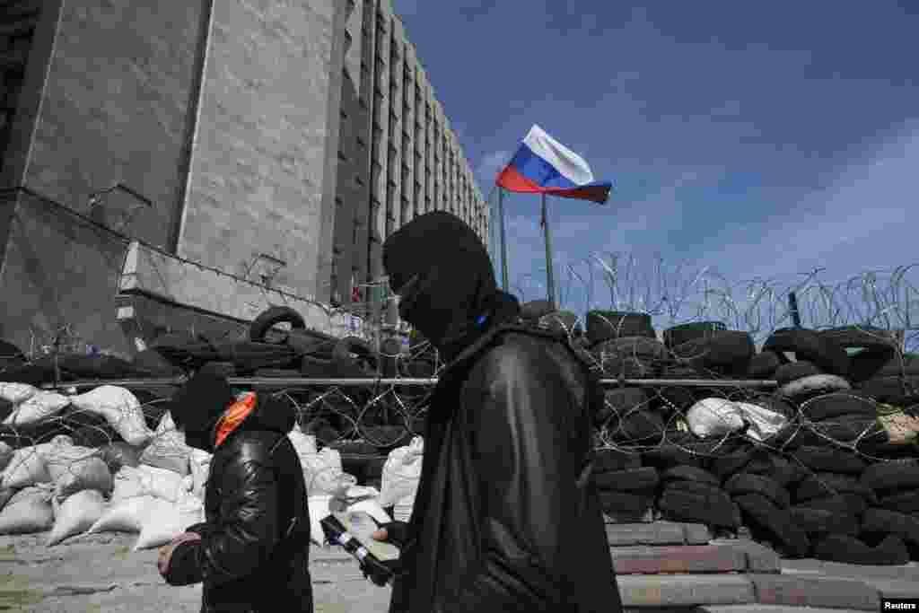 An agreement reached last week to avert wider conflict in Ukraine was faltering as the new week began, with pro-Moscow separatist gunmen showing no sign of surrendering government buildings they had seized. Here masked pro-Russian men walk past a barricade outside a regional government building in Donetsk, Ukraine, April 21, 2014. &nbsp;