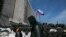 Masked pro-Russian men walk past a barricade outside a regional government building in Donetsk, eastern Ukraine April 21, 2014. An agreement reached last week to avert wider conflict in Ukraine was faltering as the new week began, with pro-Moscow separati