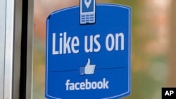 FILE - A sign with Facebook's "Like" logo is posted at Facebook headquarters in Menlo Park, Calif. 