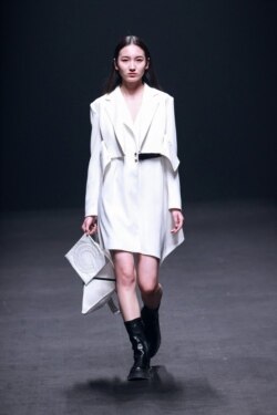 Seorang model menampilkan kreasi dari koleksi CALICO rancangan Luo Yuhao dalam Pekan Mode China di Beijing, 25 Maret 2021. (Foto: STR / AFP) / China OUT