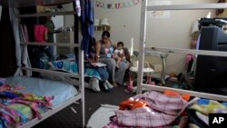 Antoine Reyes (dua dari kiri) dan istrinya Susan (tengah) membantu anak-anaknya mengerjakan PR di tempat penampungan "Union Rescue Mission" di Los Angeles (Foto: dok). Hasil sensus menunjukkan dari enam orang Amerika hidup pada atau dibawah garis kemiskinan tahun lalu.