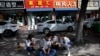 2020年5月13日，北京一个招聘服务中心外几名失业年轻人正在用手机寻找招聘信息。