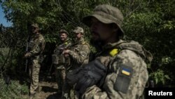 Ukrainian servicemen stand near the Ukraine-Russia border in Kharkiv region