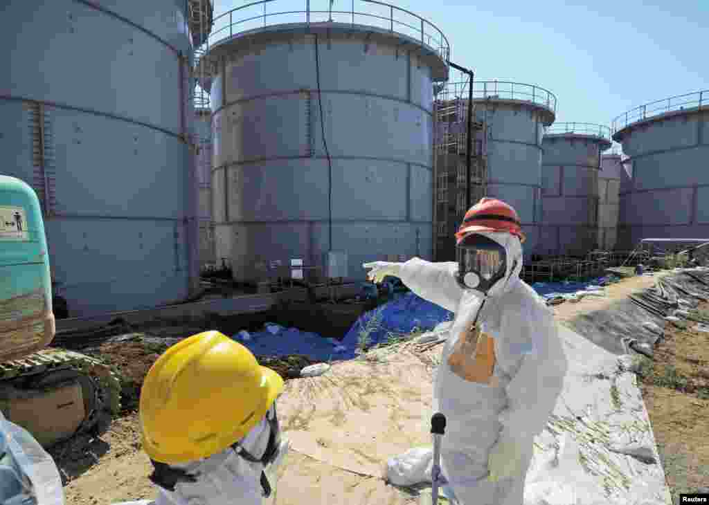 Japan&#39;s Economy, Trade and Industry Minister Toshimitsu Motegi, wearing a protective suit and a mask, inspects contaminated water tanks at the Fukushima Daiichi nuclear power plant, August 26, 2013.