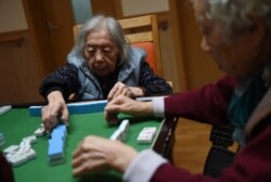 This photo taken on Nov. 22, 2015, shows elderly women playing mahjong at a nursing home in Beijing.