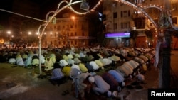 Men attend an evening mass prayer session called tarawih along a road to mark the fasting month of Ramadan in Karachi, Pakistan, May 27, 2017.