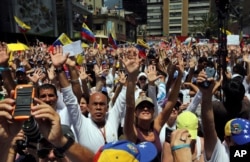 Demonstrators raise their arms in unison during a demonstration honoring the victims who died in last month's anti-government protests, in Caracas, Venezuela, March 4, 2014.