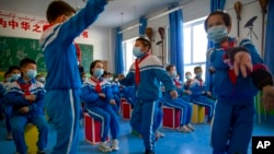 FILE - Schoolchildren dance during a music class at a primary school in Kashgar in China's Xinjiang Uyghur Autonomous Region, April 19, 2021. At the United Nations this week, 43 countries expressed in a formal statement their concerns about China's treatment of Uyghurs.