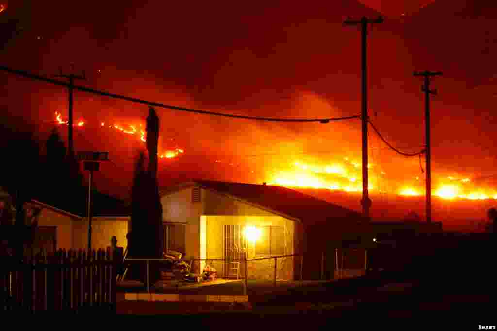 The Silver Fire burns near homes in the community of Cabazon in the early morning hours, August 8, 2013. The fire broke out shortly after 2 p.m. near a back-country road about 90 miles (145 km) outside Los Angeles.