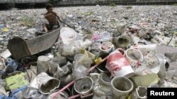 A boy collects plastic from a garbage-covered river in Manila March 21, 2010. 