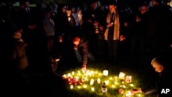 People light candles at a vigil in Leigh-on-Sea, Essex, England, Oct. 16, 2021, to honor British Conservative lawmaker David Amess, who died after being stabbed Friday. 