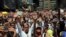 FILE - Demonstrators raise their arms in unison during a demonstration honoring the victims who died in last month's anti-government protests, in Caracas, Venezuela, March 4, 2014. 