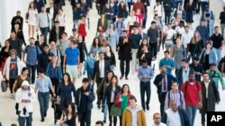 FILE - Commuters walk through a corridor in the World Trade Center Transportation Hub, in New York, June 21, 2019. 
