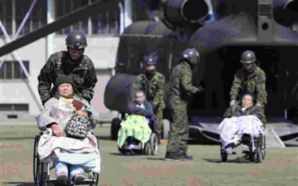 Enfermos están siendo trasladados por los oficiales de las fuerzas armadas de Japón.
