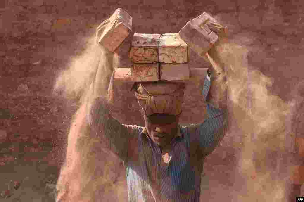 A man carries bricks at a brickfield in Saver on the outskirts of Dhaka, Bangladesh.