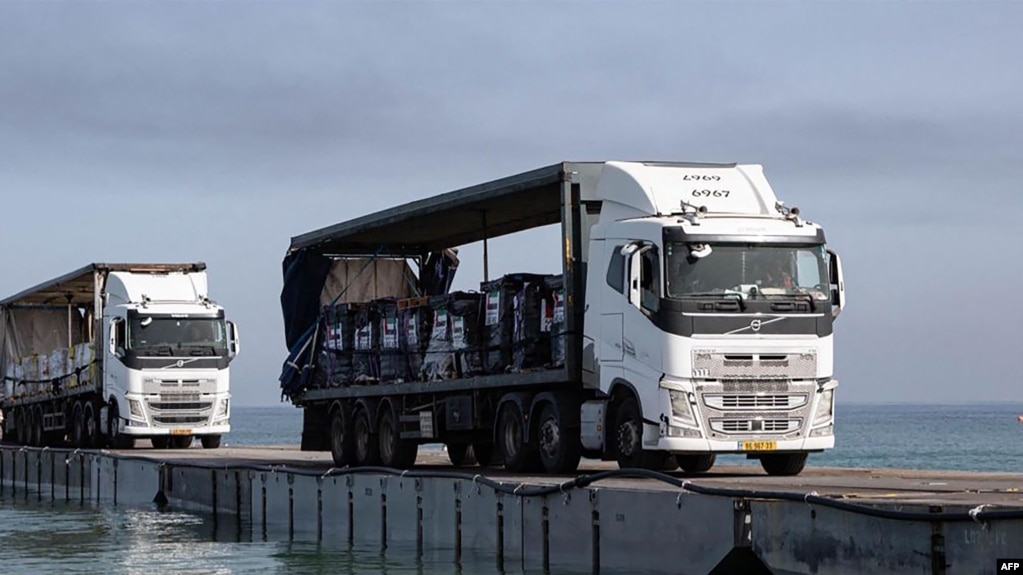 官方的阿联酋通讯社2024年5月19日发布的照片显示,阿联酋与美国国际发展署合作发出的救援物资装在卡车上，通过美国建造的海上走廊，从海上抵达加沙。(photo:VOA)