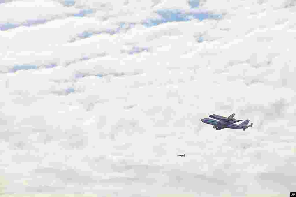 Space shuttle Discovery atop a 747 carrier jet flying over the National Mall in Washington, April 17, 2012. (VOA-A. Klein)