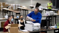 Trabajadores electorales de recuento presidencial en el Condado Fulton, en Georgia, escanean votos el 25 de noviembre de 2020, en el Georgia World Congress Center, en Atlanta.