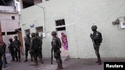 Los residentes observan mientras los miembros de las Fuerzas Armadas de Brasil patrullan durante una operación contra narcotraficantes en la favela Cidade de Deus en Río de Janeiro, Brasil, el 7 de febrero de 2018. REUTERS / Ricardo Moraes.